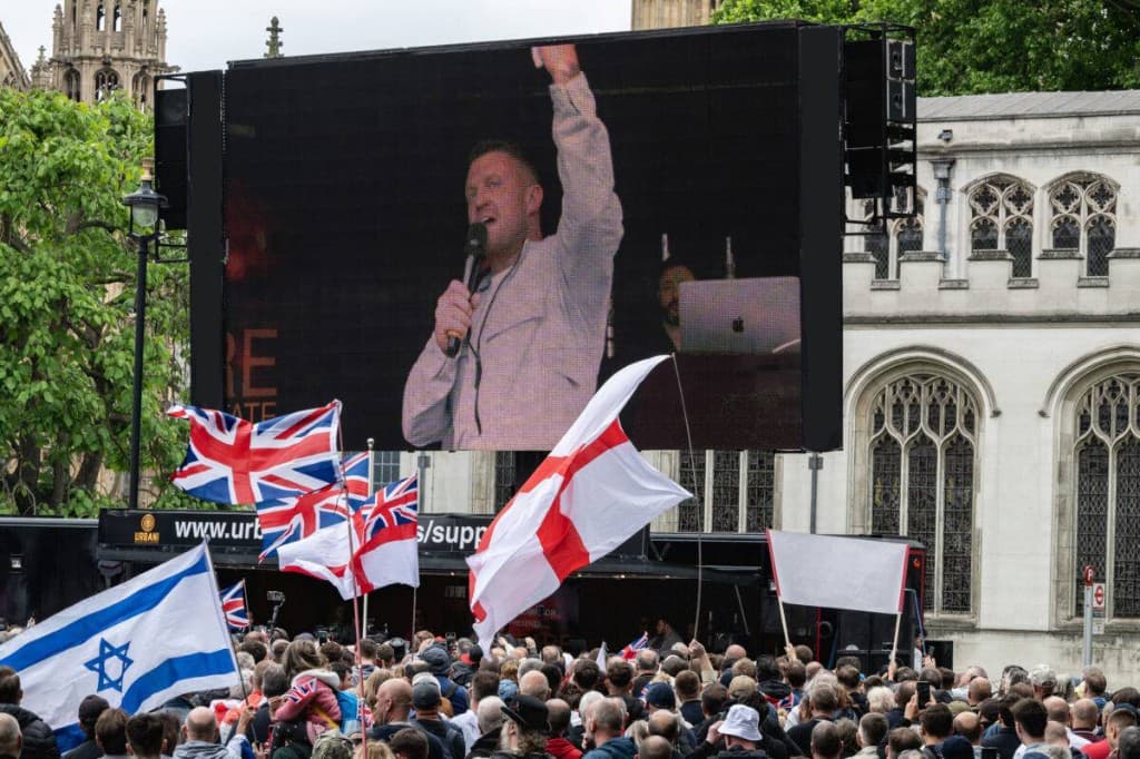 Outdoor rally with large screen showing the speaker